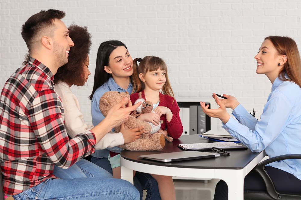 Social worker meeting with couple for signing adoption documents in Rochester, NY